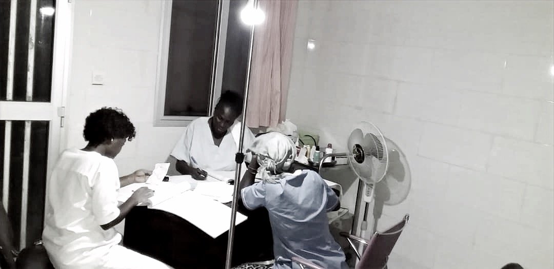 2019年8月、Ndiao Bambaly 診療所の夜間。ランプの下で記録をつける